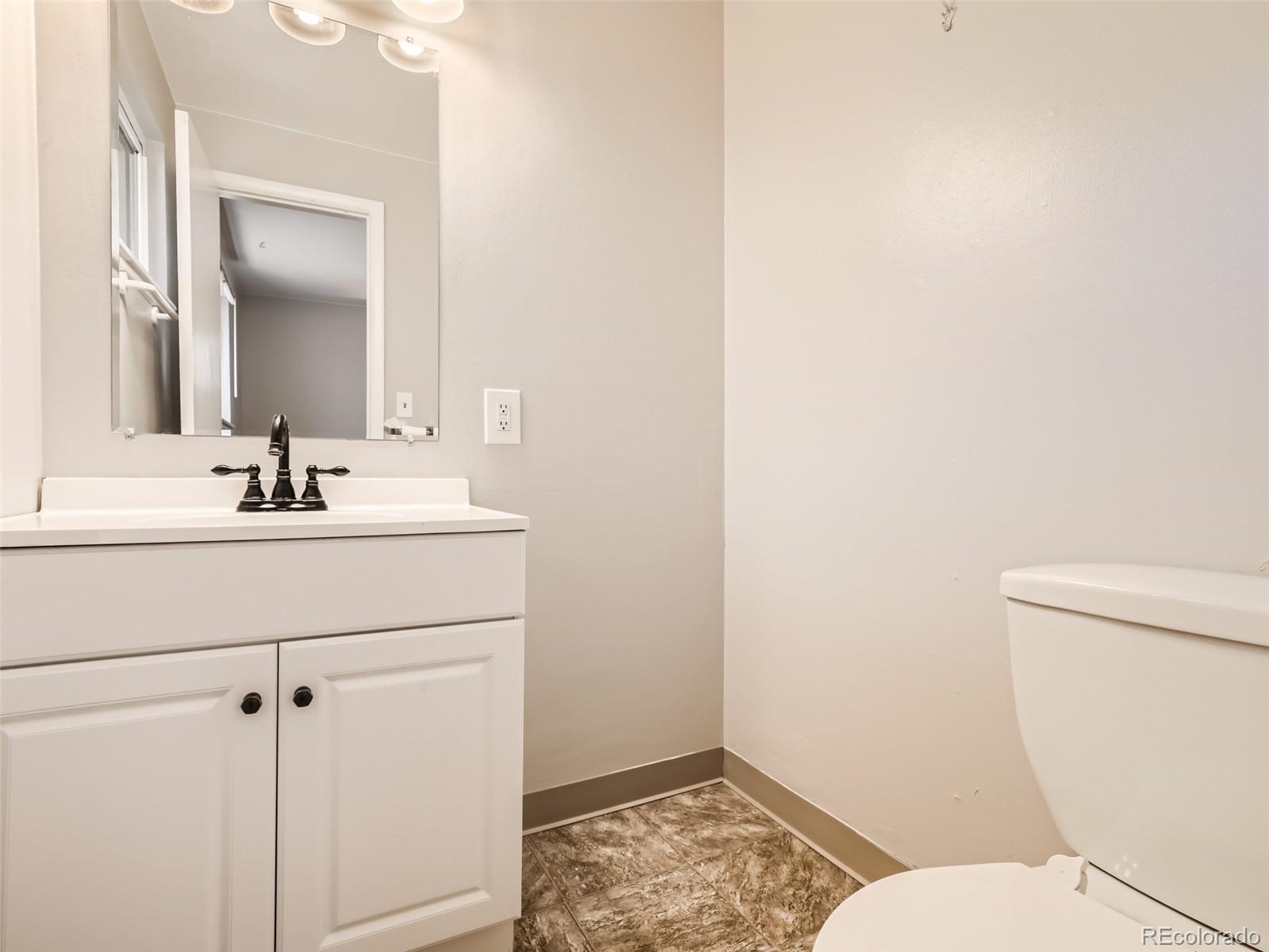 6930 North Locust Street Commerce City, CO 80022 - Photo 6 of 17 a bathroom with a sink toilet and vanity