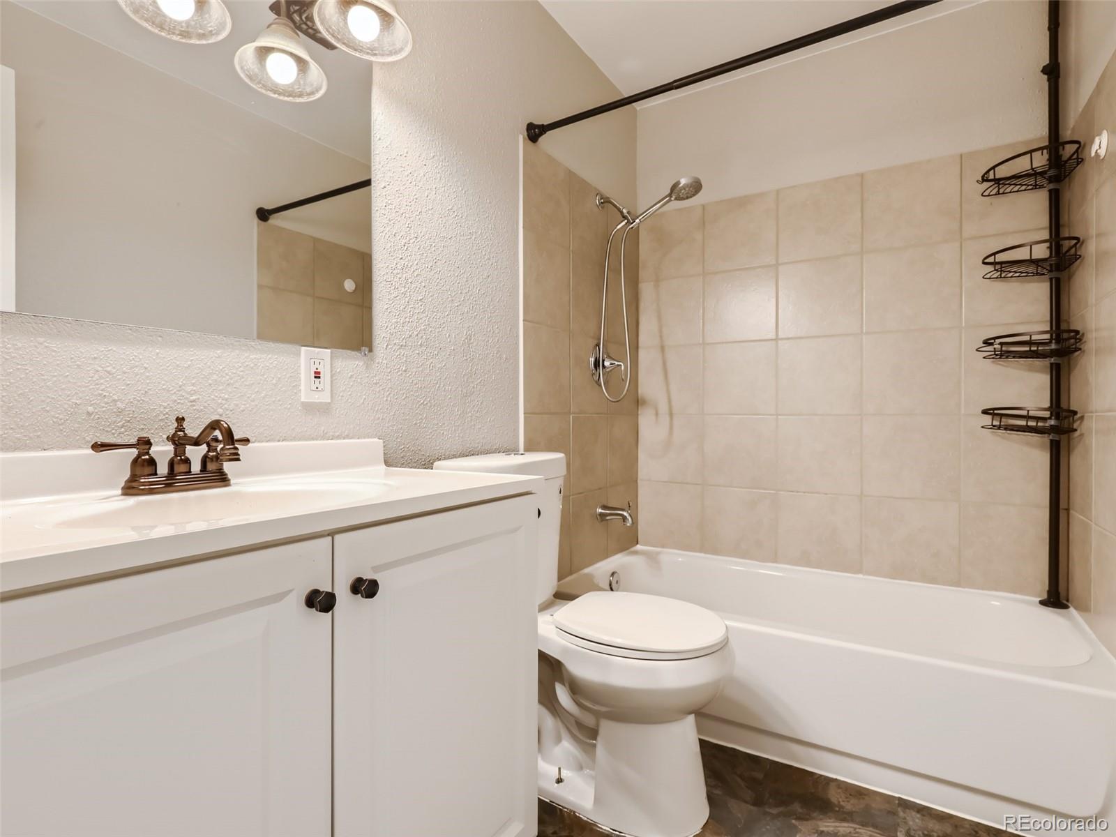 6930 North Locust Street Commerce City, CO 80022 - Photo 10 of 17 a bathroom with a sink a toilet and shower