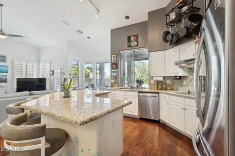 a kitchen with stainless steel appliances granite countertop a sink a stove and a refrigerator