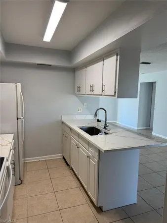 a kitchen with a sink a counter top space cabinets and stainless steel appliances