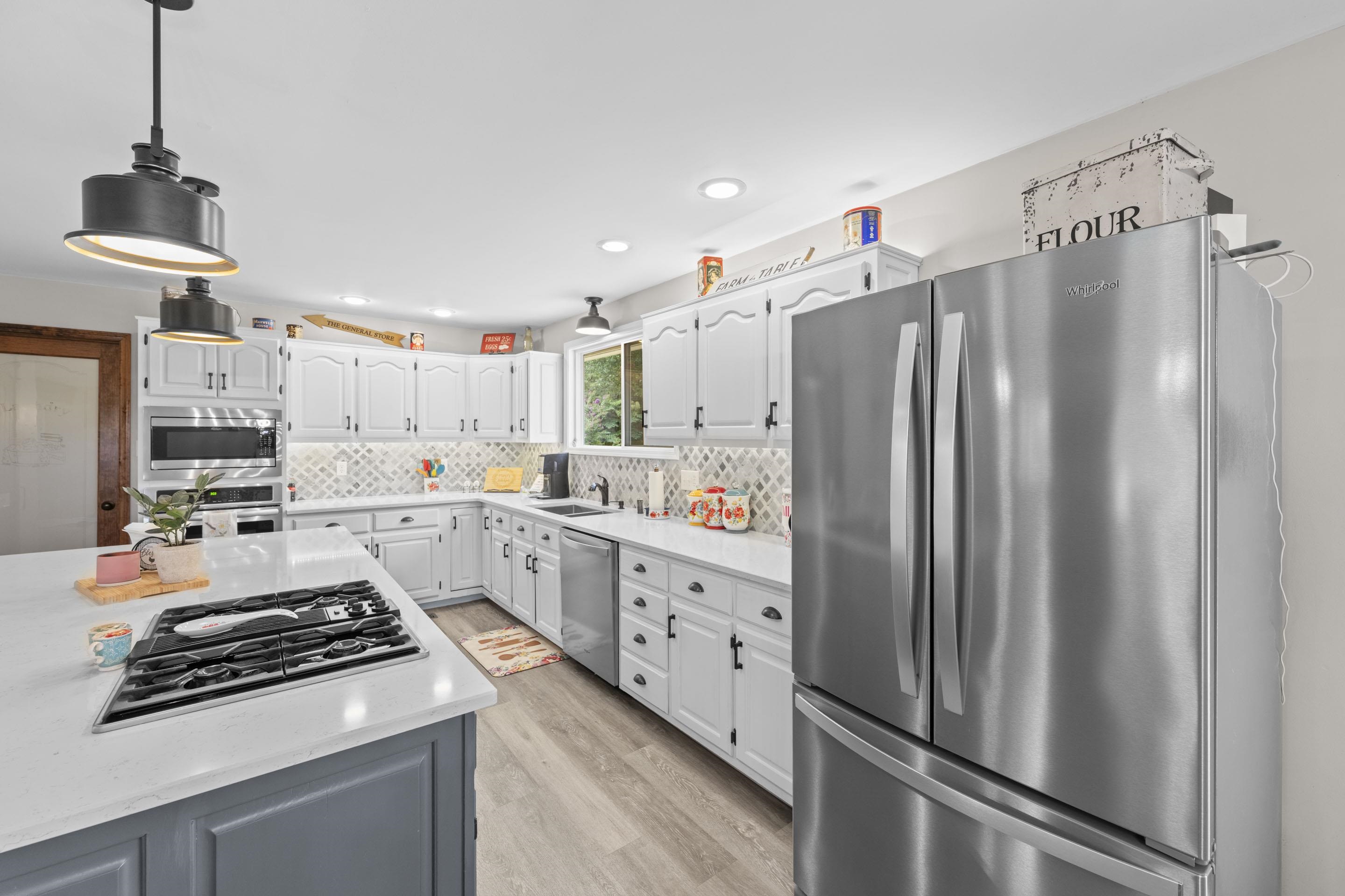 849 Belton Road Ripley, TN 38063 - Photo 16 of 40 a kitchen with stainless steel appliances a refrigerator sink and wooden floor