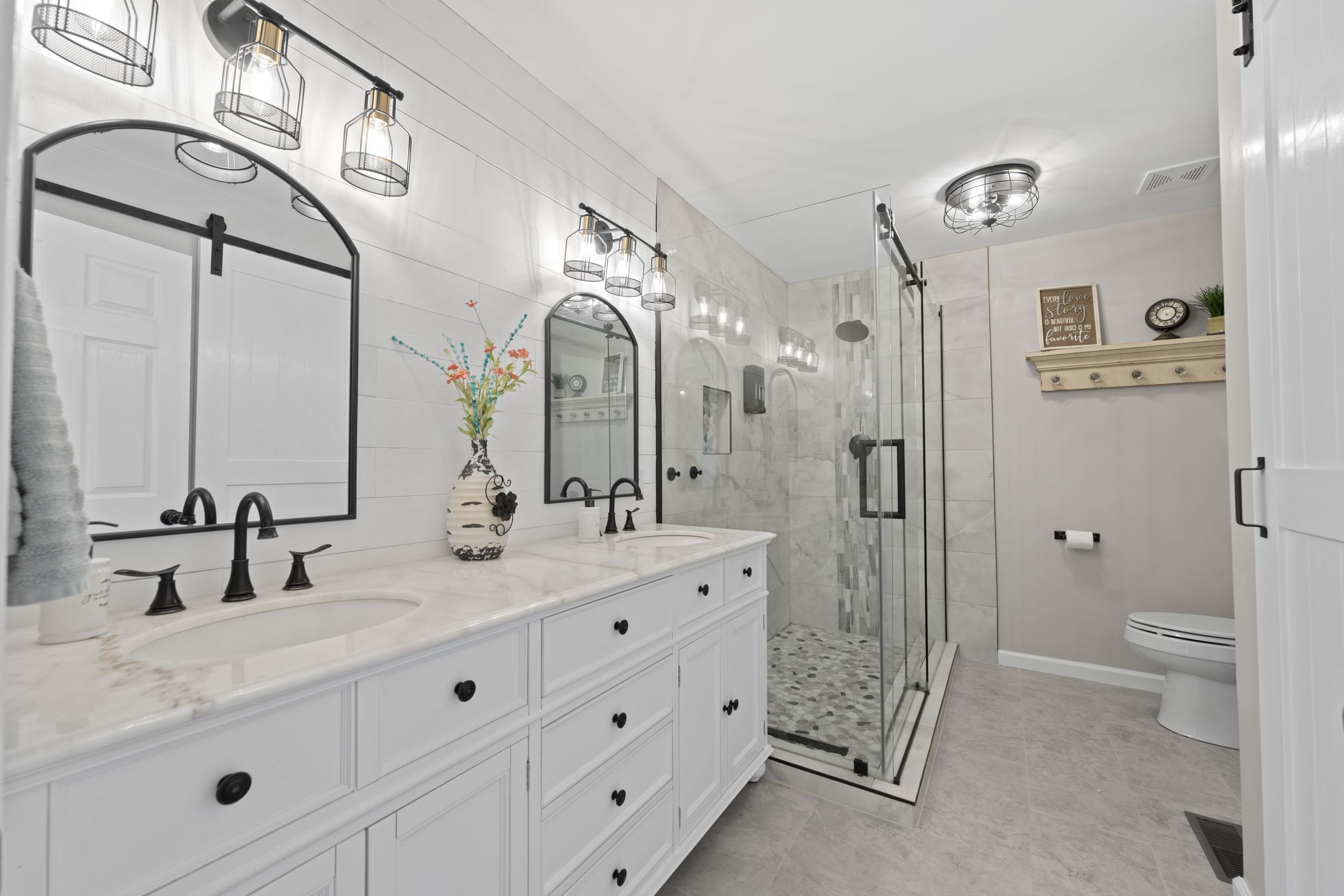 849 Belton Road Ripley, TN 38063 - Photo 21 of 40 a bathroom with a double vanity sink mirror double and shower