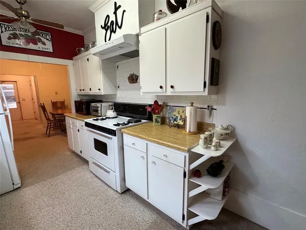 a kitchen with stainless steel appliances a sink a stove and white cabinets