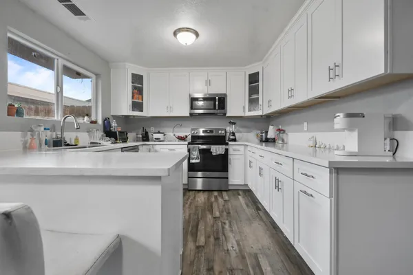 a kitchen with stainless steel appliances granite countertop a sink a stove and cabinets