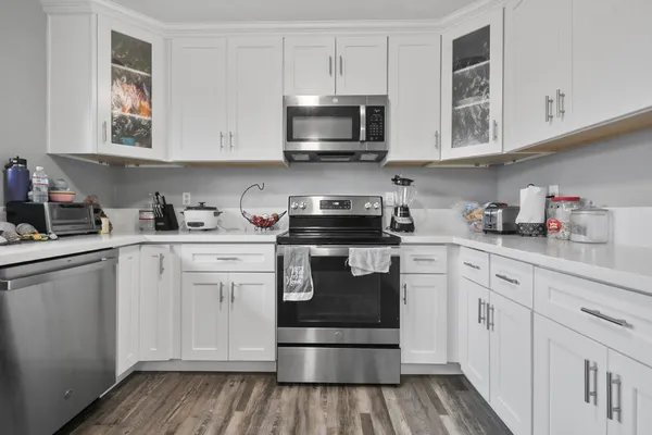 a kitchen with white cabinets stainless steel appliances and sink