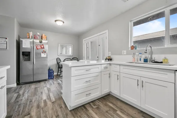 a kitchen with stainless steel appliances cabinets and a wooden floor