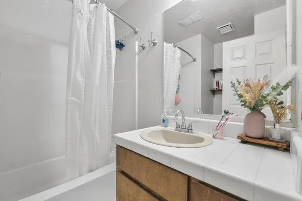 a bathroom with a sink a tub and a mirror