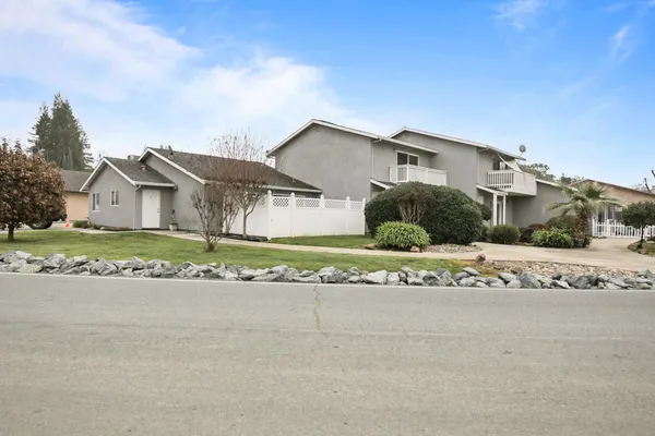 a front view of a house with a garden and yard