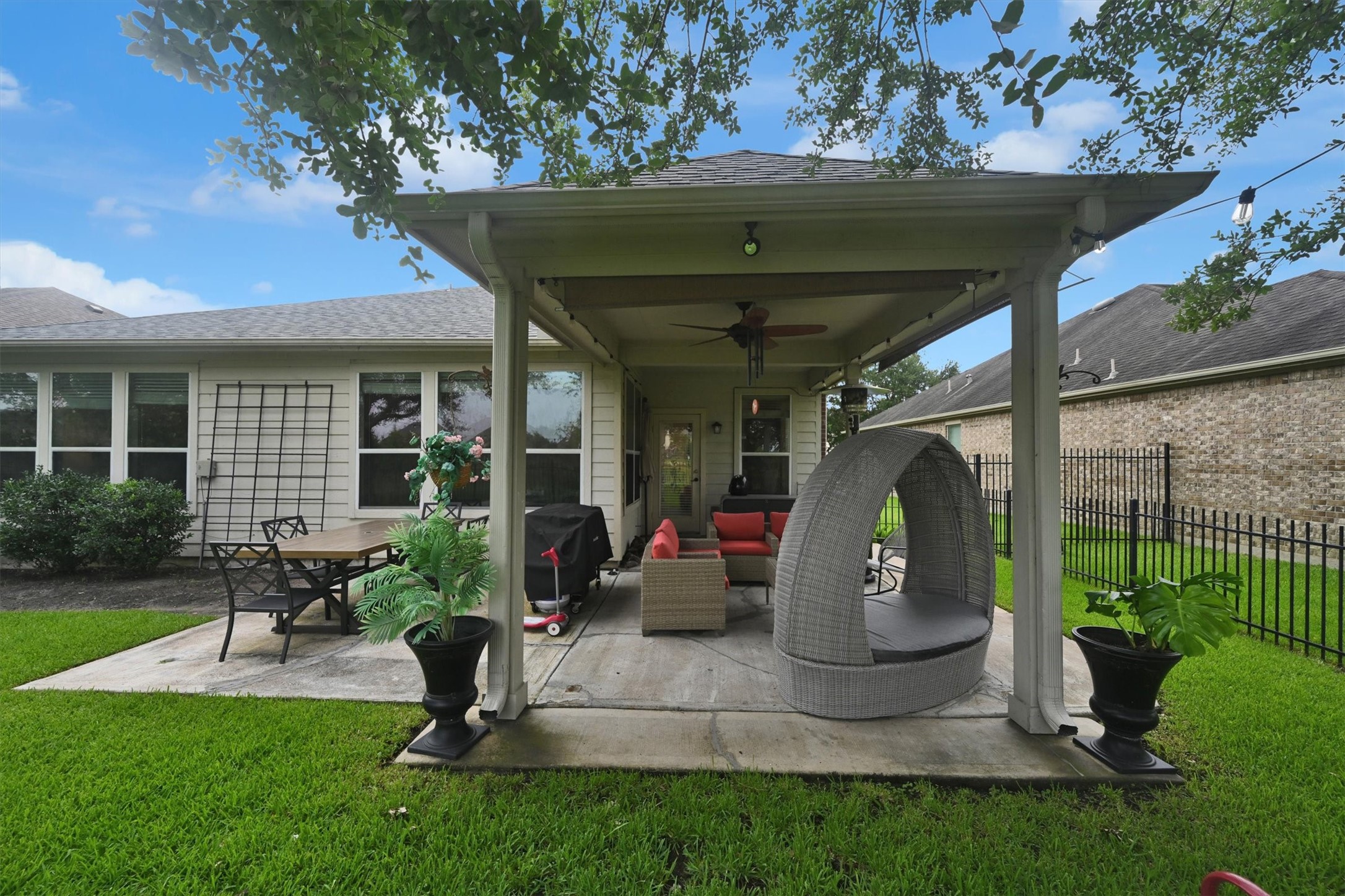 a view of a patio with table and chairs potted plants and a large tree