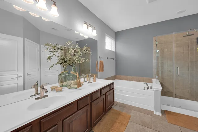 a bathroom with a tub double sink and mirror