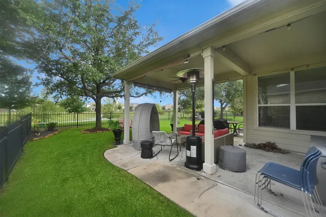 a view of a patio with table and chairs potted plants and a large tree