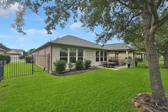 a front view of a house with swimming pool and green space