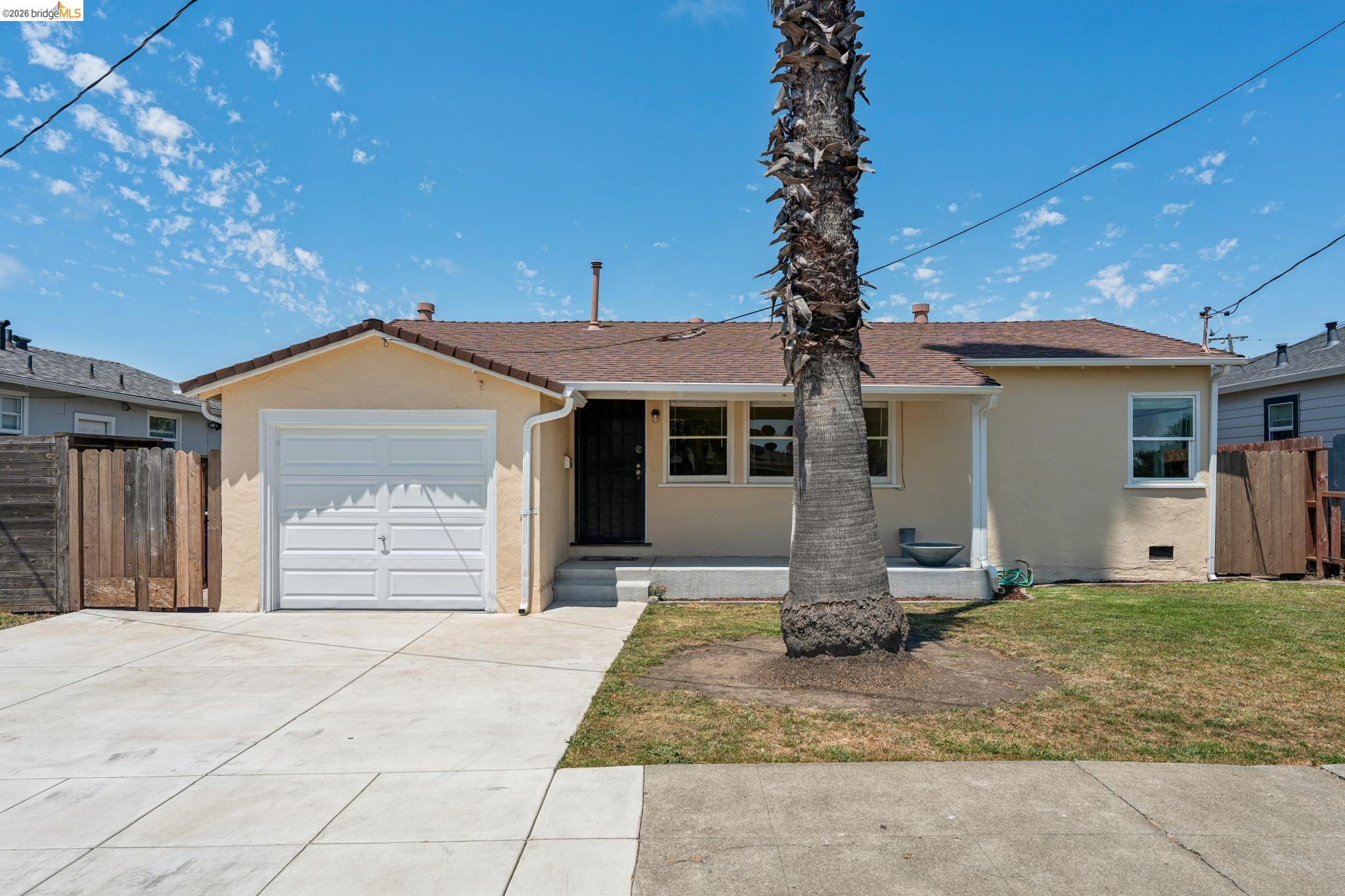 2879 Rheem Avenue Richmond, CA 94804 - Photo 4 of 45 Single-story exterior with stucco siding, a brown shingle roof, and a palm tree in the front yard