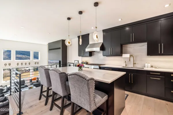 a kitchen with a sink a stove and chairs