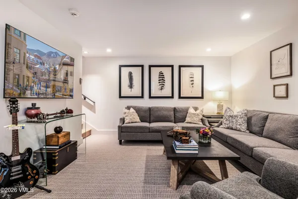 a living room with furniture and paintings on the wall