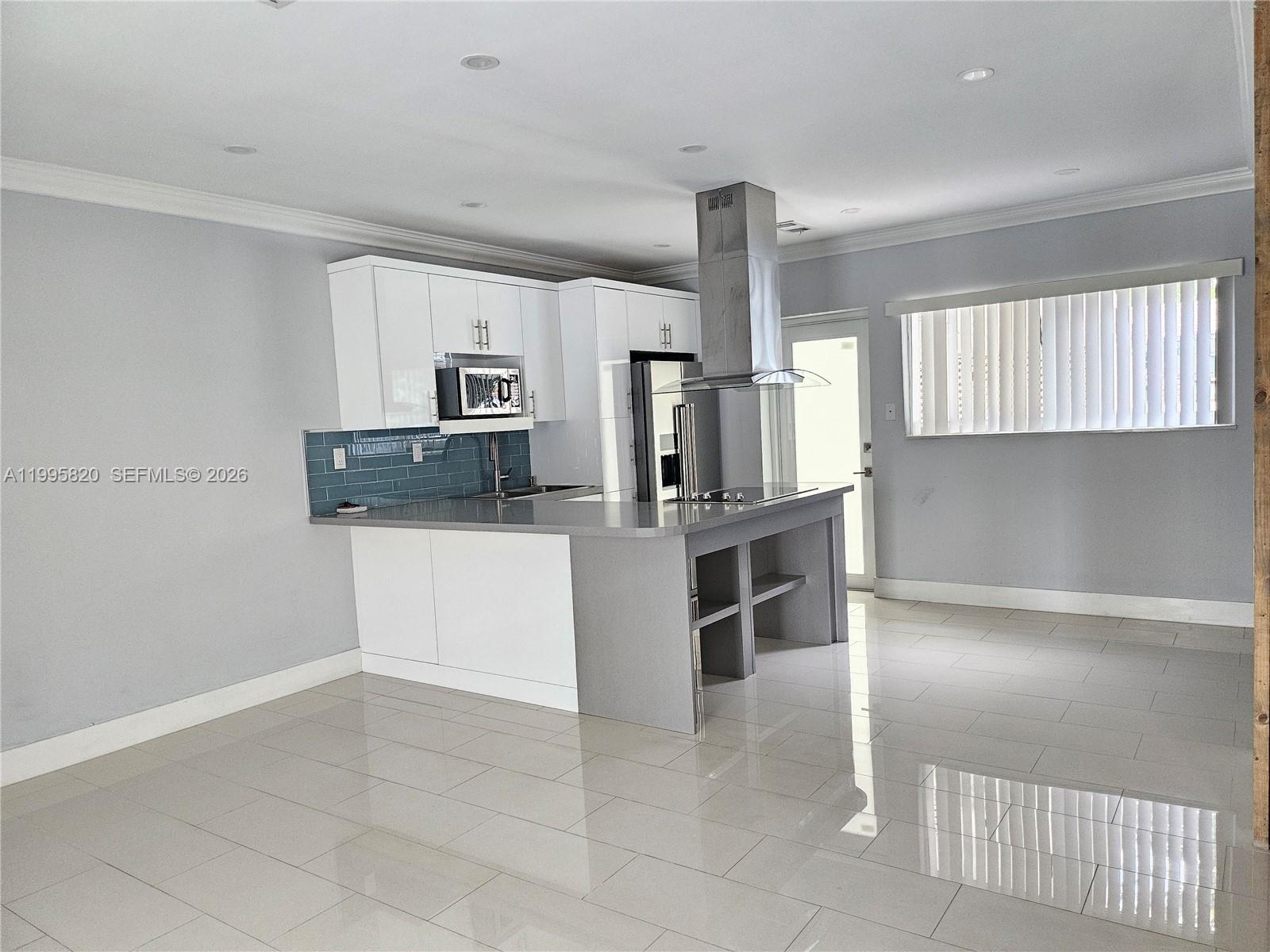 5816 Southwest 9th Street West Miami, FL 33144 - Photo 6 of 12 a kitchen with granite countertop a refrigerator and a stove top oven
