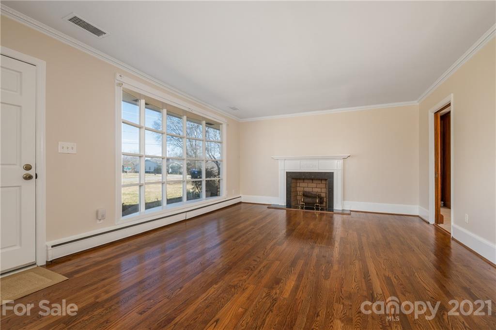 285 Tanner Street Rutherfordton, NC 28139 - Photo 5 of 39 wooden floor fireplace and windows in an empty room