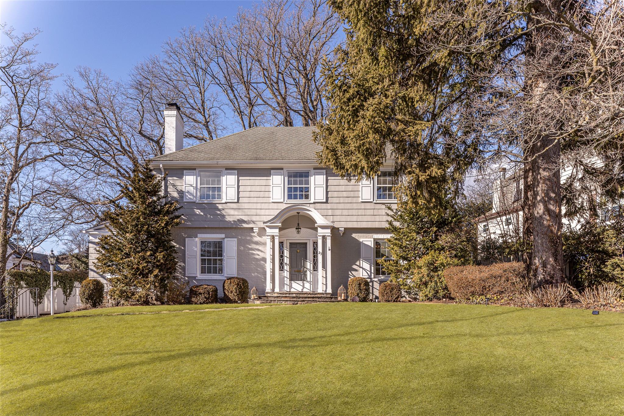 View of front of property featuring a front lawn, a chimney, and fence