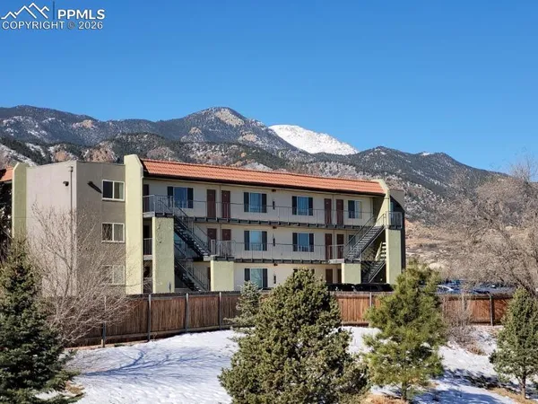 a front view of a house with a yard and mountain view