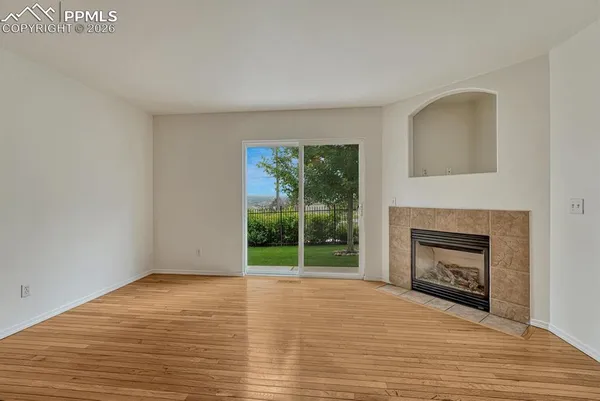 a view of empty room with wooden floor fireplace