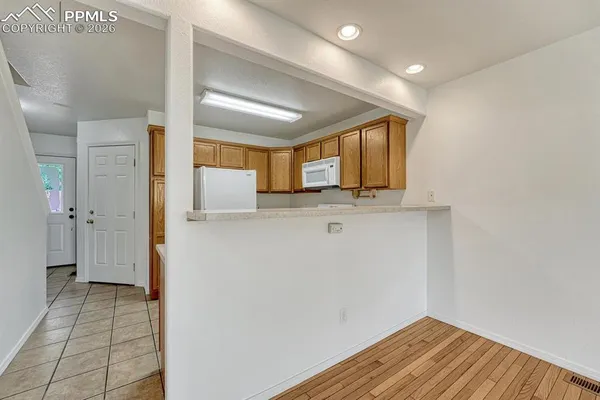a view of kitchen with stainless steel appliances cabinets and wooden floor