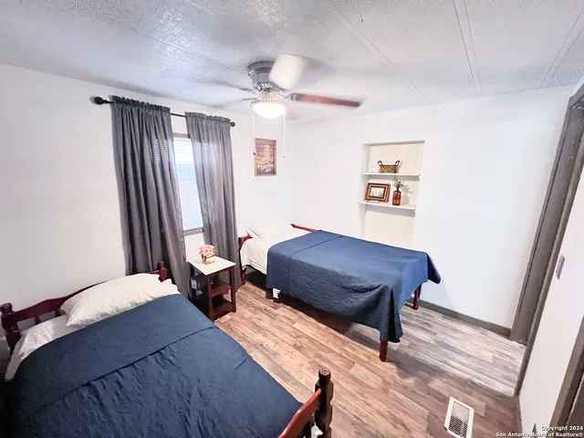 a bedroom with a bed and wooden floor