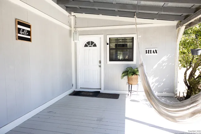 a view of a hallway with wooden floor and a potted plant