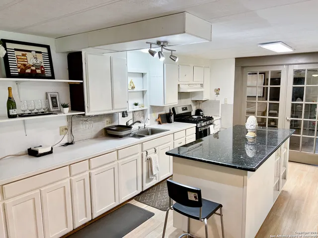 a kitchen with stainless steel appliances granite countertop a sink and a white cabinets