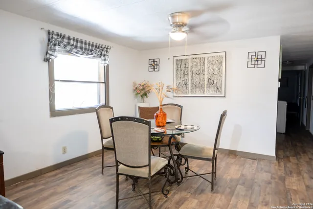 a view of a dining room with furniture a chandelier and wooden floor