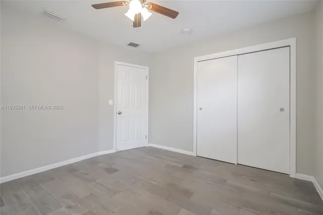 an empty room with chandelier fan