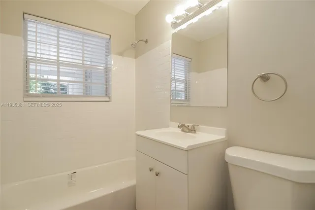 a bathroom with a sink toilet vanity and tub