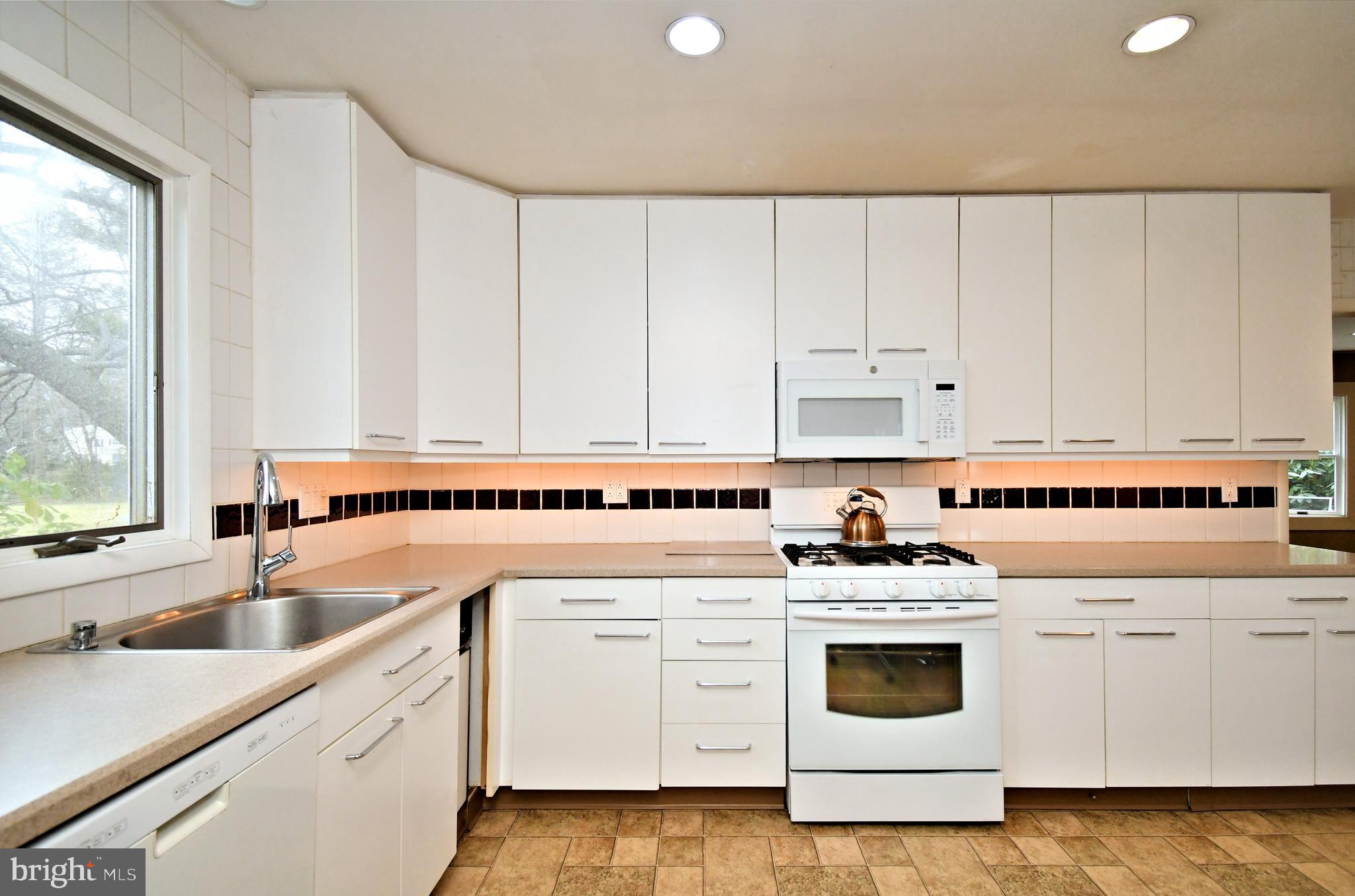 1658 Cavan Drive Dresher, PA 19025 - Photo 7 of 25 a kitchen with granite countertop white cabinets and white appliances