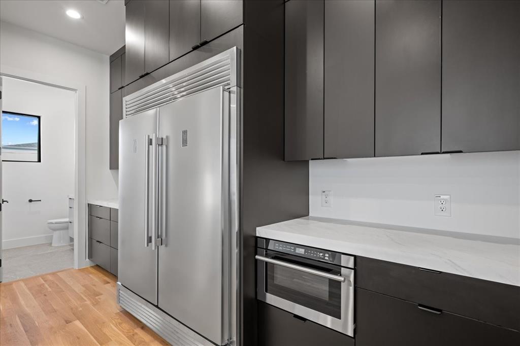 4517 Weldon Street Dallas, TX 75204 - Photo 12 of 40 a kitchen with stainless steel appliances a refrigerator and cabinets