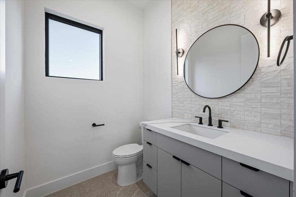 4517 Weldon Street Dallas, TX 75204 - Photo 13 of 40 a bathroom with a toilet sink and mirror