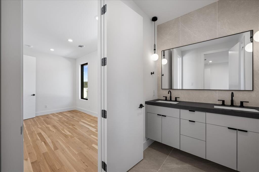 4517 Weldon Street Dallas, TX 75204 - Photo 22 of 40 a spacious bathroom with a double vanity sink and mirror