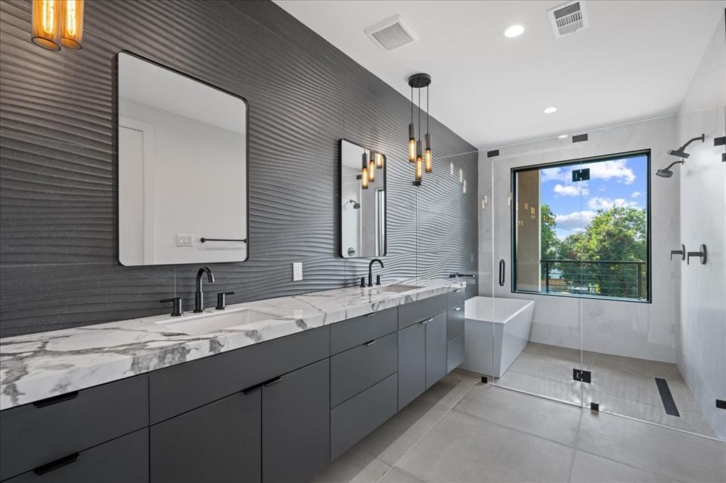4517 Weldon Street Dallas, TX 75204 - Photo 30 of 40 a bathroom with a granite countertop sink mirror and a bathtub