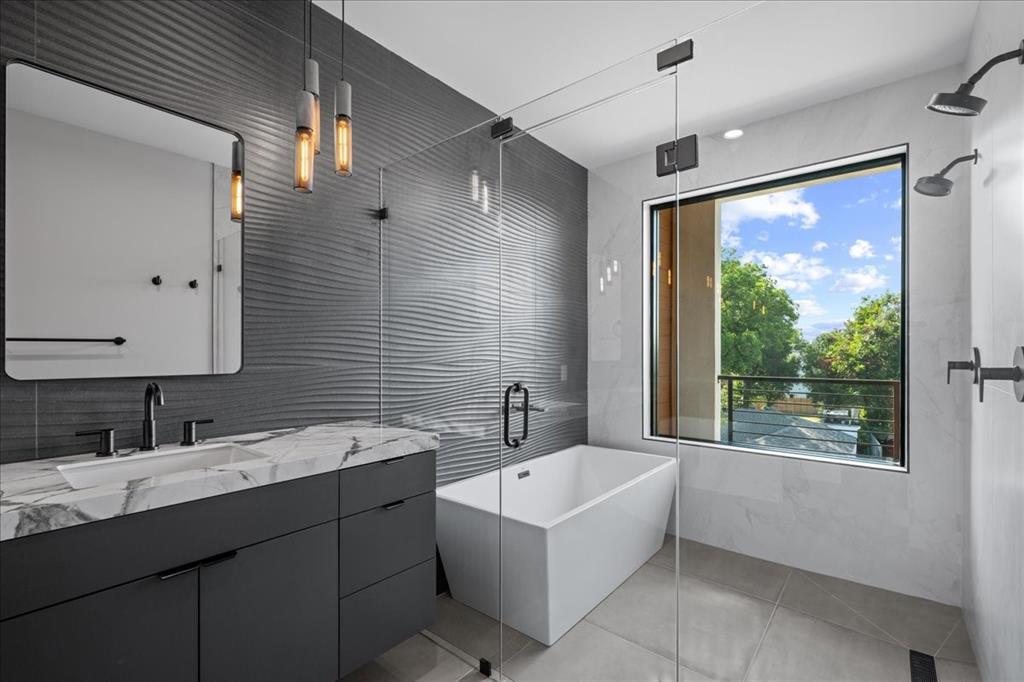 4517 Weldon Street Dallas, TX 75204 - Photo 31 of 40 a bathroom with a double vanity sink large mirror and a bathtub