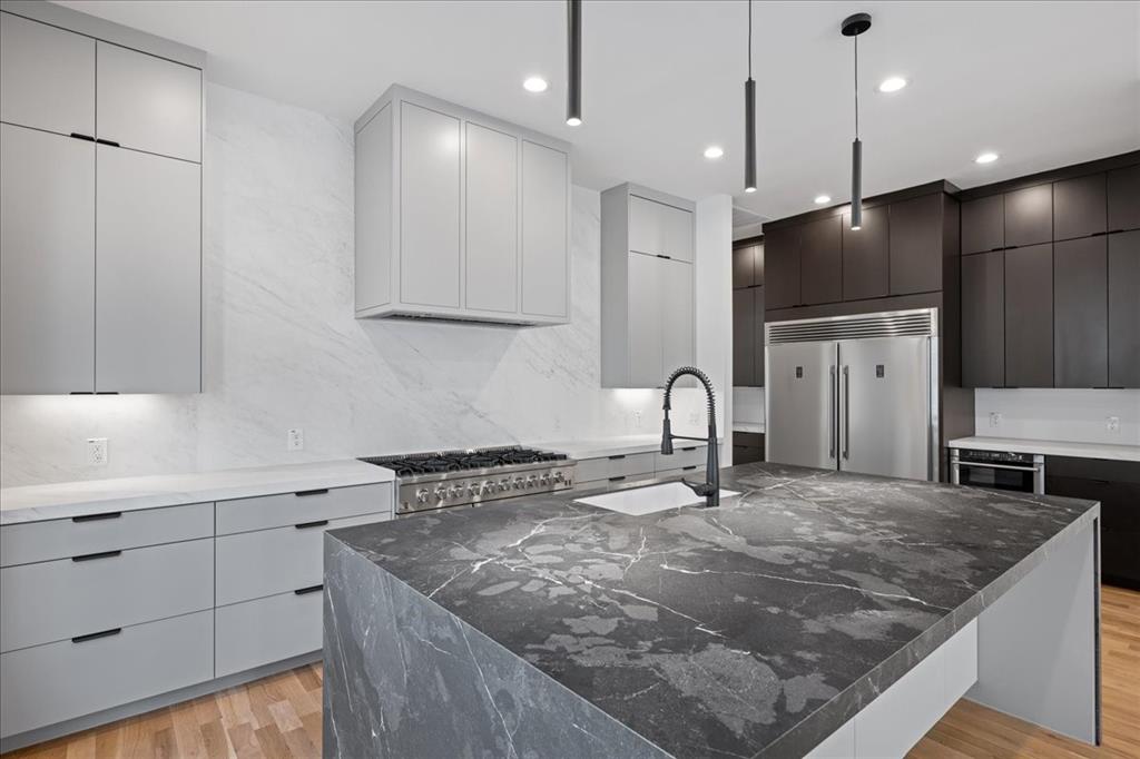4517 Weldon Street Dallas, TX 75204 - Photo 9 of 40 a kitchen with stainless steel appliances granite countertop a sink a stove and a refrigerator