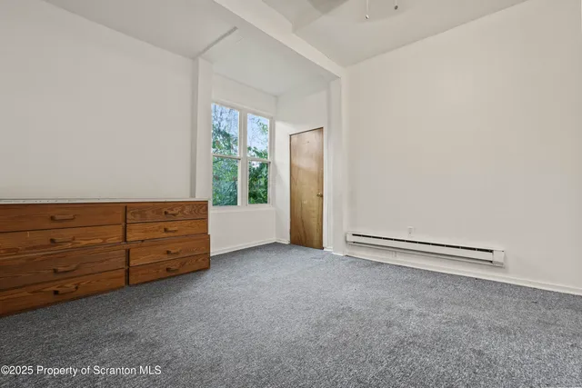 an empty room with windows and cabinet