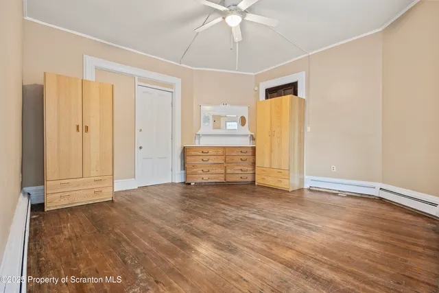 a view of an empty room with wooden floor