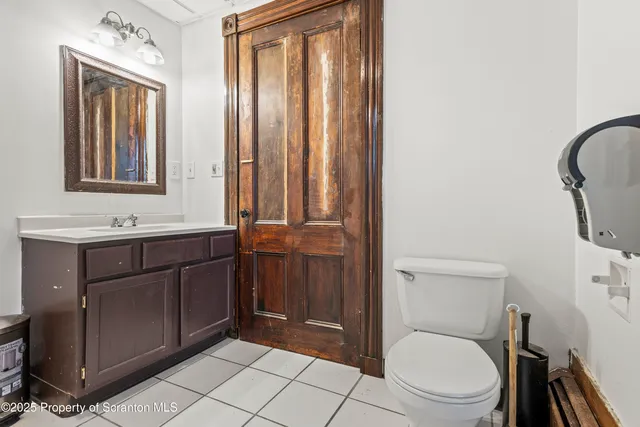 a bathroom with a toilet a sink a mirror and vanity