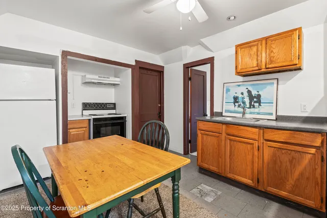 a kitchen with stainless steel appliances kitchen island a table chairs in it and a refrigerator