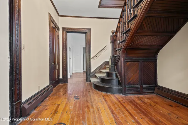 a view of entryway and hall with wooden floor