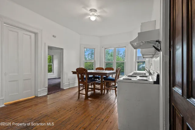 a dining room with furniture and wooden floor