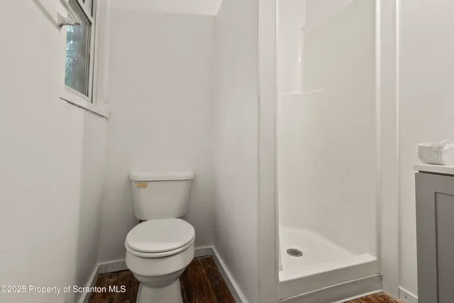 a bathroom with a toilet and a shower