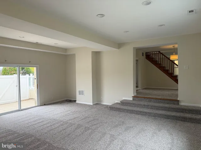 a view of an empty room with stairs and ventilation