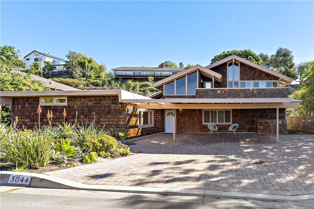 3044 Cresta Way Laguna Beach, CA 92651 - Photo 2 of 48 a front view of a house with a yard and potted plants
