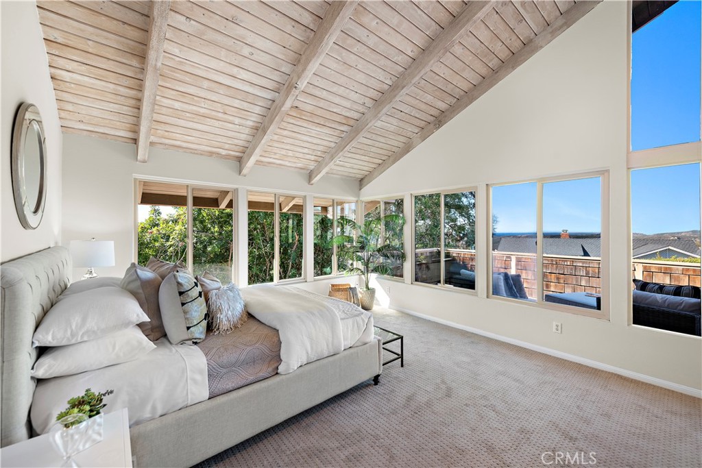 3044 Cresta Way Laguna Beach, CA 92651 - Photo 22 of 48 a bed sitting in a spacious bedroom next to a large window with the balcony view