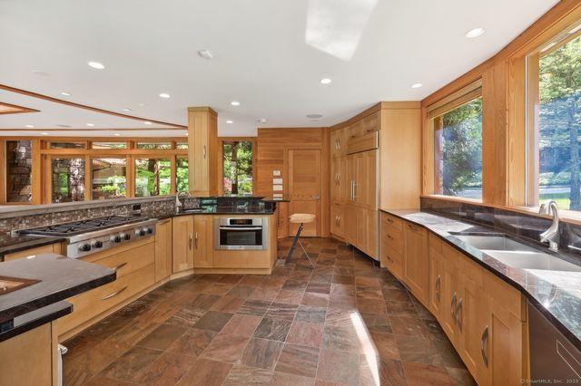 a large kitchen with stainless steel appliances a large window and counter space