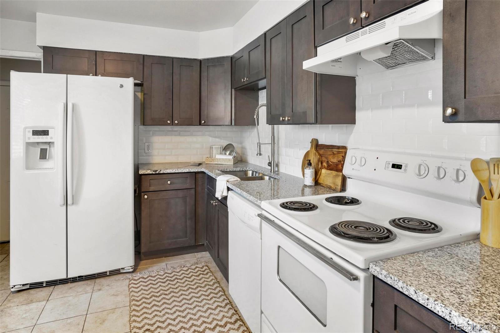 5522 Carson Street Denver, CO 80239 - Photo 12 of 40 a kitchen with a stove a refrigerator and a sink